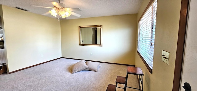 carpeted bedroom featuring baseboards, visible vents, ceiling fan, and a textured ceiling