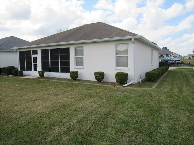 2459 NW 55th Avenue Rd, Ocala, FL 34482 - back of property with a sunroom, a shingled roof, a lawn, and stucco siding