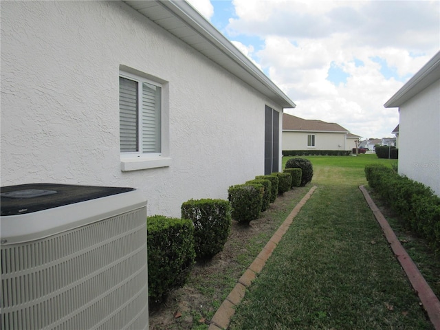 2459 NW 55th Avenue Rd, Ocala, FL 34482 - view of home's exterior featuring a lawn, cooling unit, and stucco siding