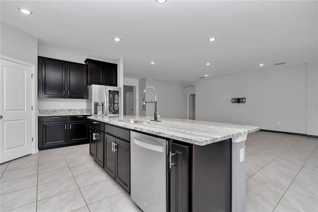 kitchen featuring an island with sink, light tile patterned flooring, stainless steel appliances, a sink, and recessed lighting