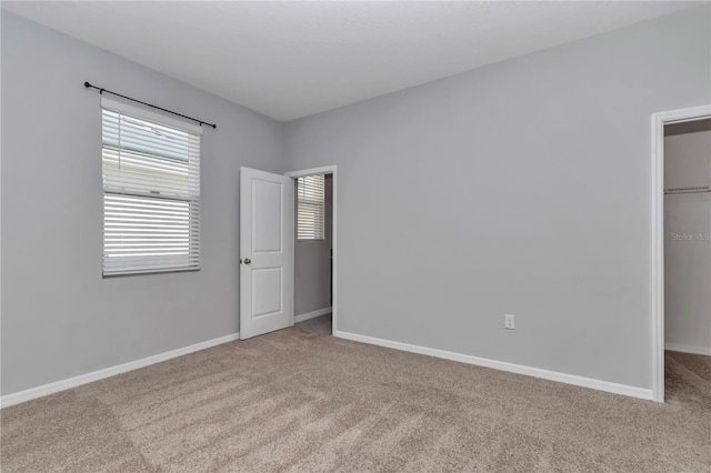 carpeted empty room featuring baseboards