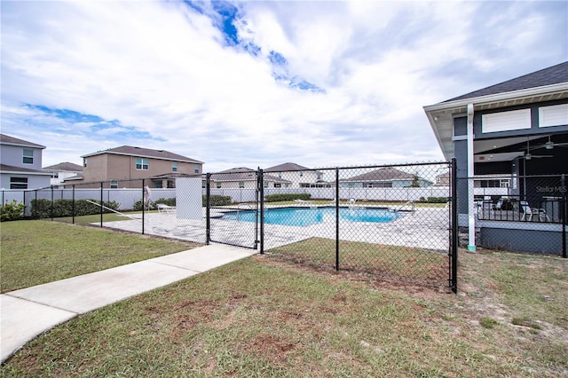 view of pool with a fenced in pool, fence, a lawn, and a residential view