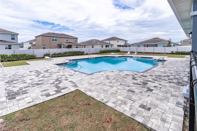 community pool with a residential view, a patio area, and fence