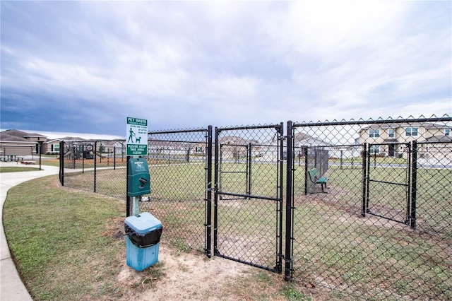 view of gate with a yard and fence