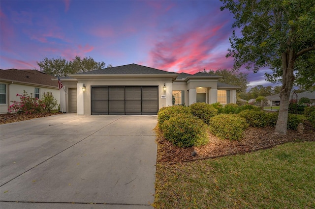 view of front of house featuring a garage, driveway, and stucco siding