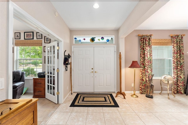 foyer entrance with light tile patterned floors and baseboards