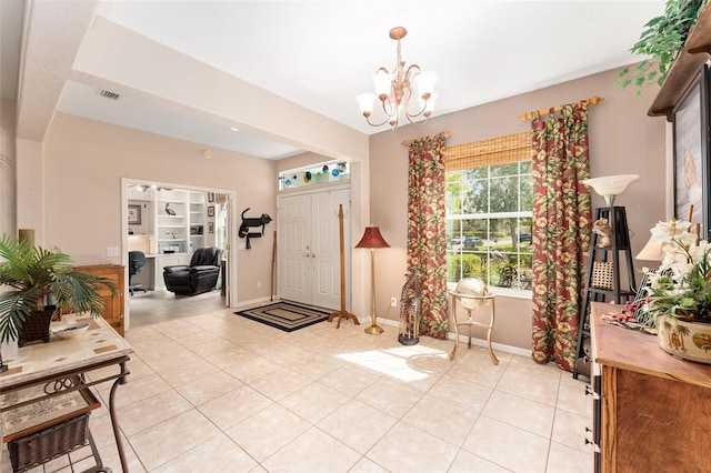 entryway featuring light tile patterned floors, visible vents, baseboards, and an inviting chandelier