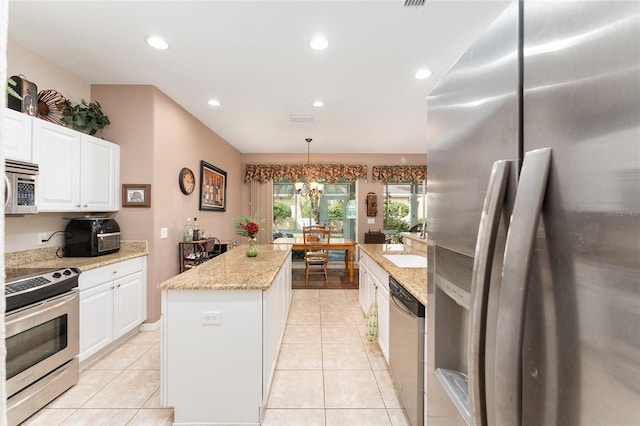 kitchen featuring appliances with stainless steel finishes, recessed lighting, white cabinets, and a center island