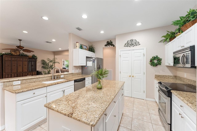 kitchen featuring stainless steel appliances, visible vents, a sink, a kitchen island, and a peninsula