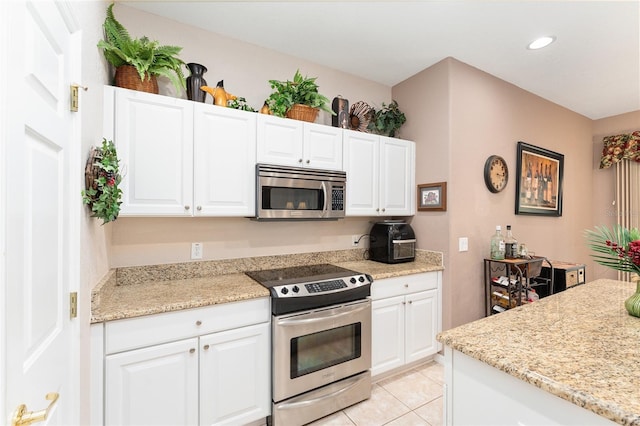 kitchen featuring light tile patterned floors, stainless steel appliances, and white cabinets