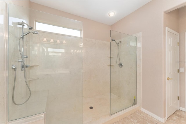 full bath with baseboards, a walk in shower, and tile patterned floors