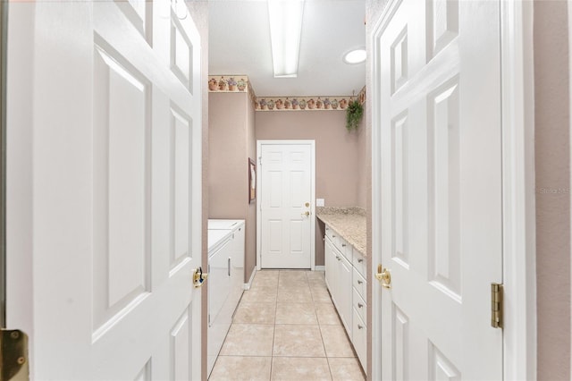 bathroom featuring washing machine and dryer, vanity, and tile patterned floors