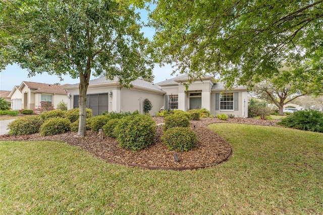 view of front of home with a front yard, an attached garage, and stucco siding