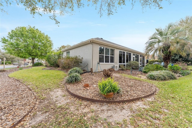 exterior space featuring a lawn and stucco siding