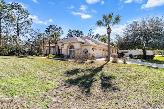 mediterranean / spanish house featuring an attached garage, a front yard, concrete driveway, and stucco siding