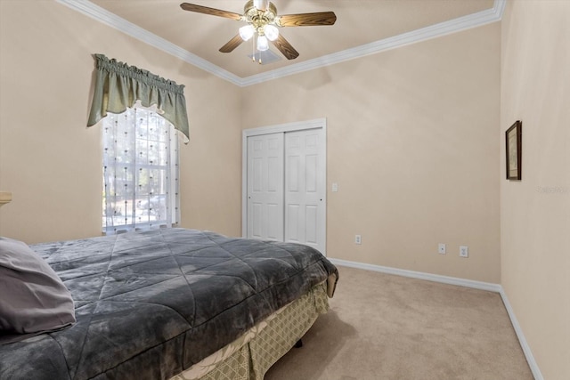 bedroom featuring carpet floors, a closet, ornamental molding, a ceiling fan, and baseboards