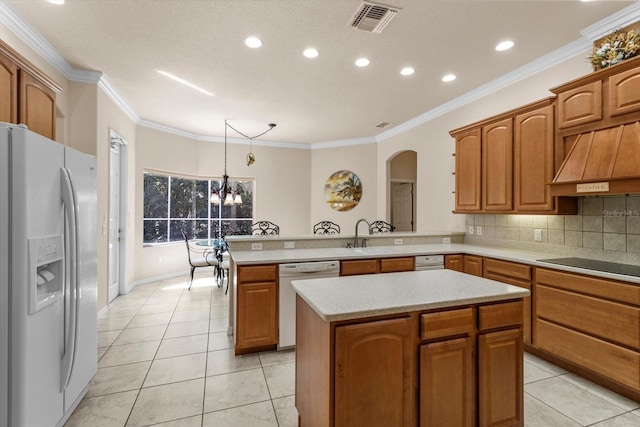 kitchen featuring white appliances, visible vents, custom range hood, a peninsula, and light countertops