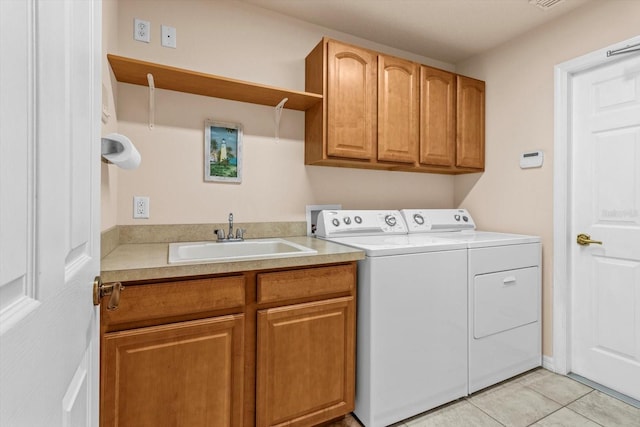 washroom featuring light tile patterned floors, a sink, cabinet space, and washer and dryer