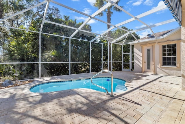 view of pool featuring glass enclosure and a patio area