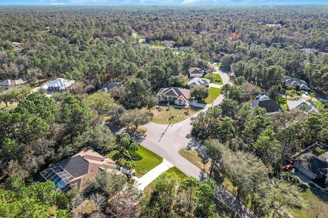 drone / aerial view featuring a wooded view and a residential view