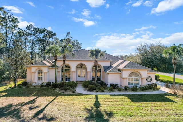 mediterranean / spanish-style home featuring french doors, a front lawn, and stucco siding