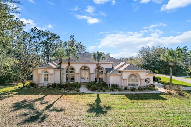 mediterranean / spanish house with stucco siding and a front yard