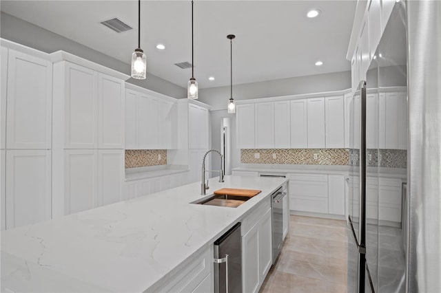 kitchen featuring tasteful backsplash, visible vents, white cabinets, appliances with stainless steel finishes, and a sink