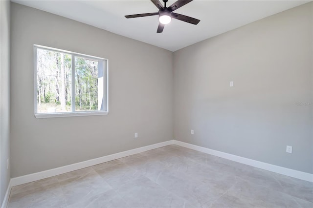 spare room featuring ceiling fan and baseboards