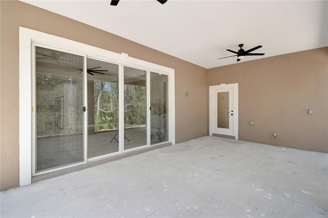 unfurnished room with ceiling fan and concrete flooring