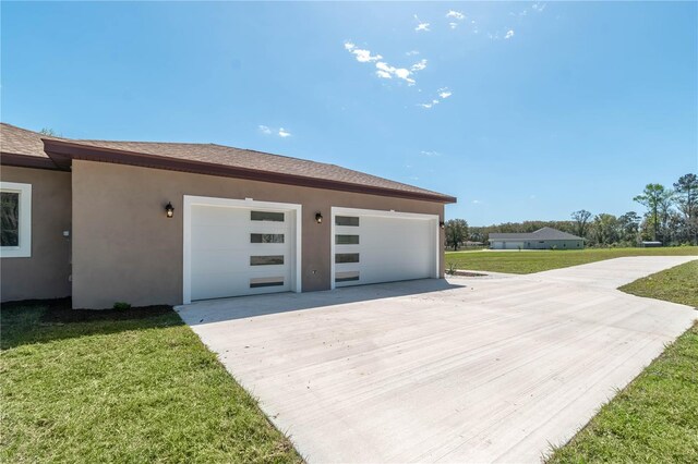 view of property exterior with a garage, concrete driveway, a lawn, and stucco siding