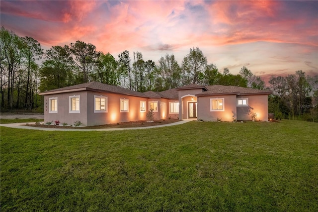 view of front facade featuring a yard and stucco siding