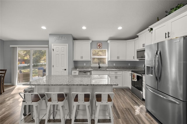 kitchen with stainless steel appliances, a healthy amount of sunlight, white cabinetry, and a sink