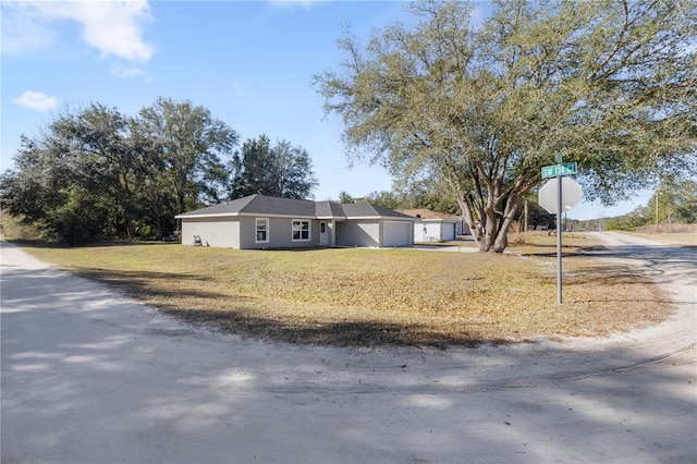 ranch-style house featuring a garage, driveway, and a front lawn