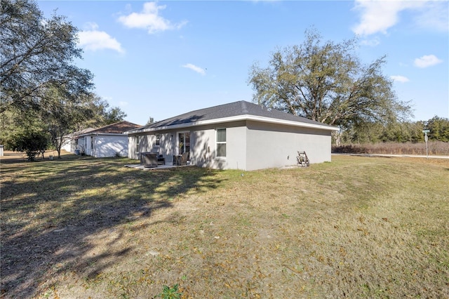 exterior space with a lawn and stucco siding