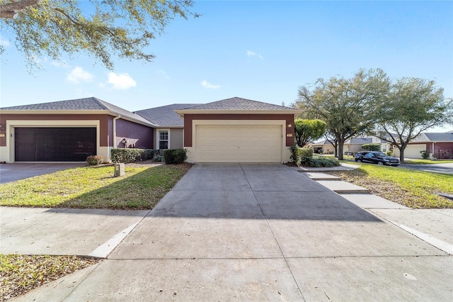 view of front of property featuring an attached garage, a front yard, concrete driveway, and stucco siding