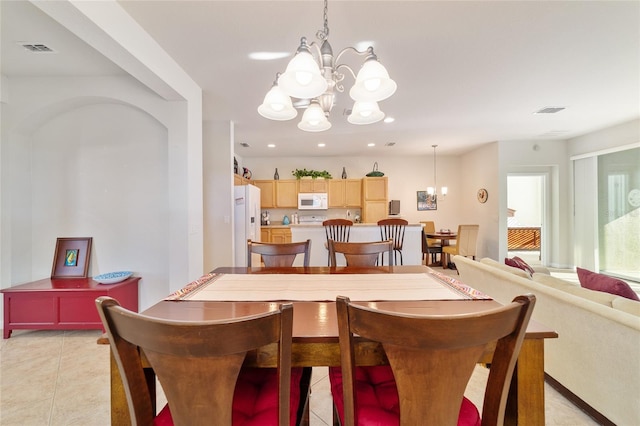 dining room featuring light tile patterned floors, visible vents, and a notable chandelier