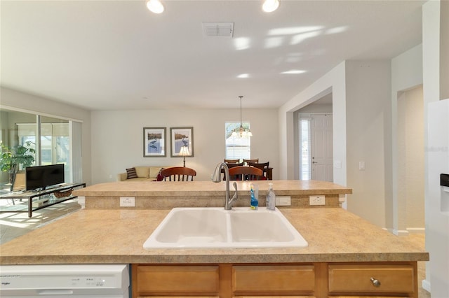 kitchen featuring visible vents, dishwasher, open floor plan, light countertops, and a sink