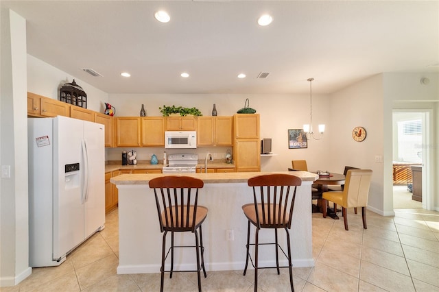 kitchen featuring light brown cabinets, white appliances, visible vents, light countertops, and a center island with sink