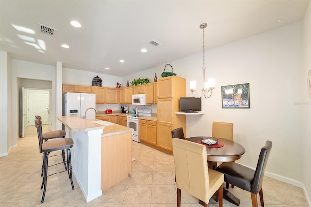 kitchen with light brown cabinets, white appliances, a sink, visible vents, and light countertops