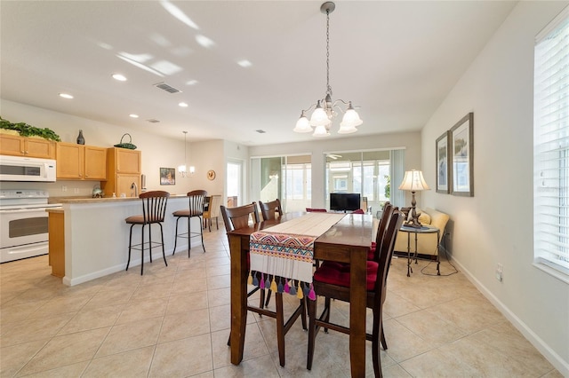 dining area featuring light tile patterned floors, baseboards, visible vents, and a notable chandelier