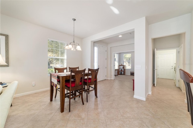 dining room featuring a chandelier, baseboards, and light tile patterned floors