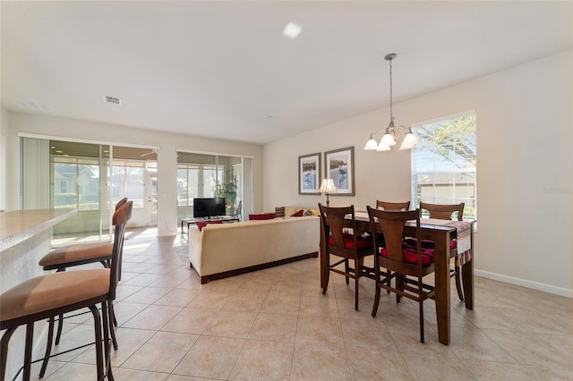 dining room featuring light tile patterned floors, visible vents, baseboards, and a chandelier