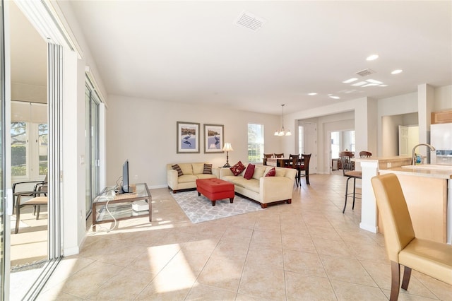 living area with light tile patterned floors, visible vents, and baseboards