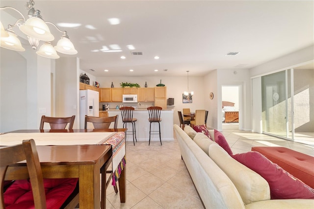 dining space featuring light tile patterned floors, recessed lighting, visible vents, and an inviting chandelier