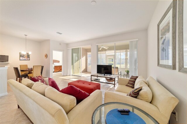 living area with light tile patterned flooring, visible vents, and a notable chandelier