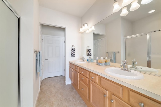 full bathroom with a stall shower, a sink, and tile patterned floors