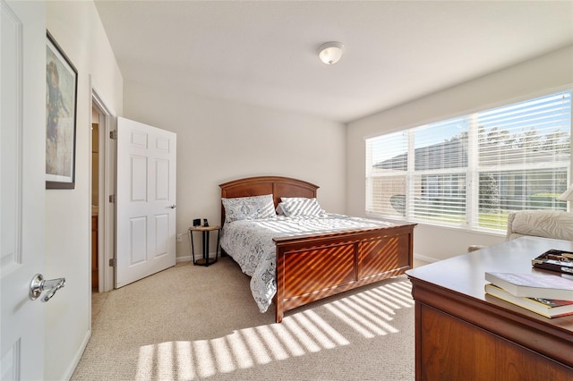 bedroom featuring light carpet and baseboards