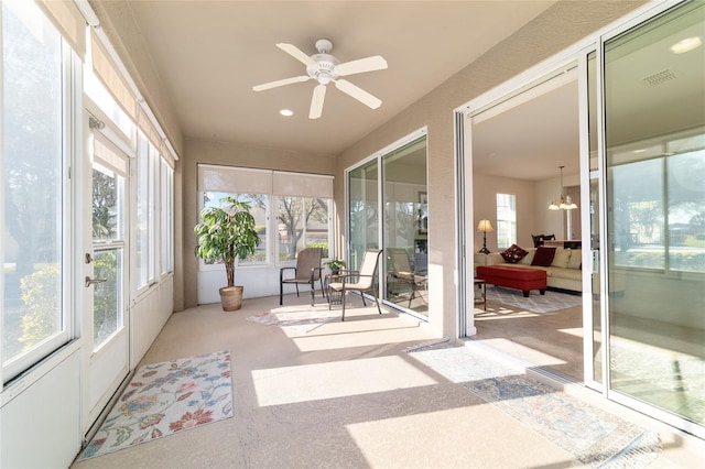 sunroom with a healthy amount of sunlight, ceiling fan, and visible vents