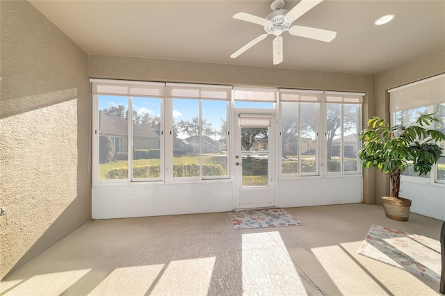 unfurnished sunroom with a ceiling fan