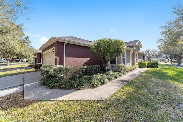 view of home's exterior with a yard, concrete driveway, an attached garage, and stucco siding